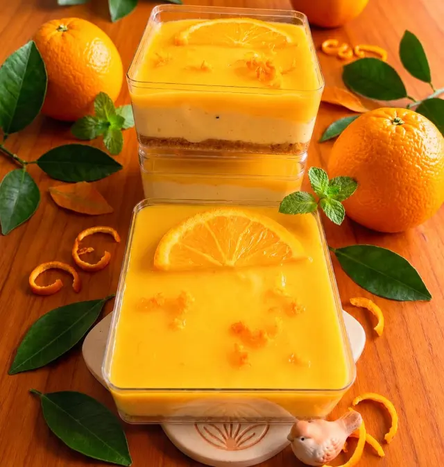 Orange cheesecake tubs with orange slices and zest